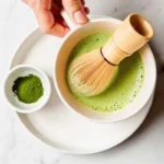 Whisking matcha green tea with coconut milk using a bamboo chasen