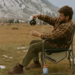 Man enjoying milk tea outdoors in a mountain setting, illustrating milk tea calories in everyday moments