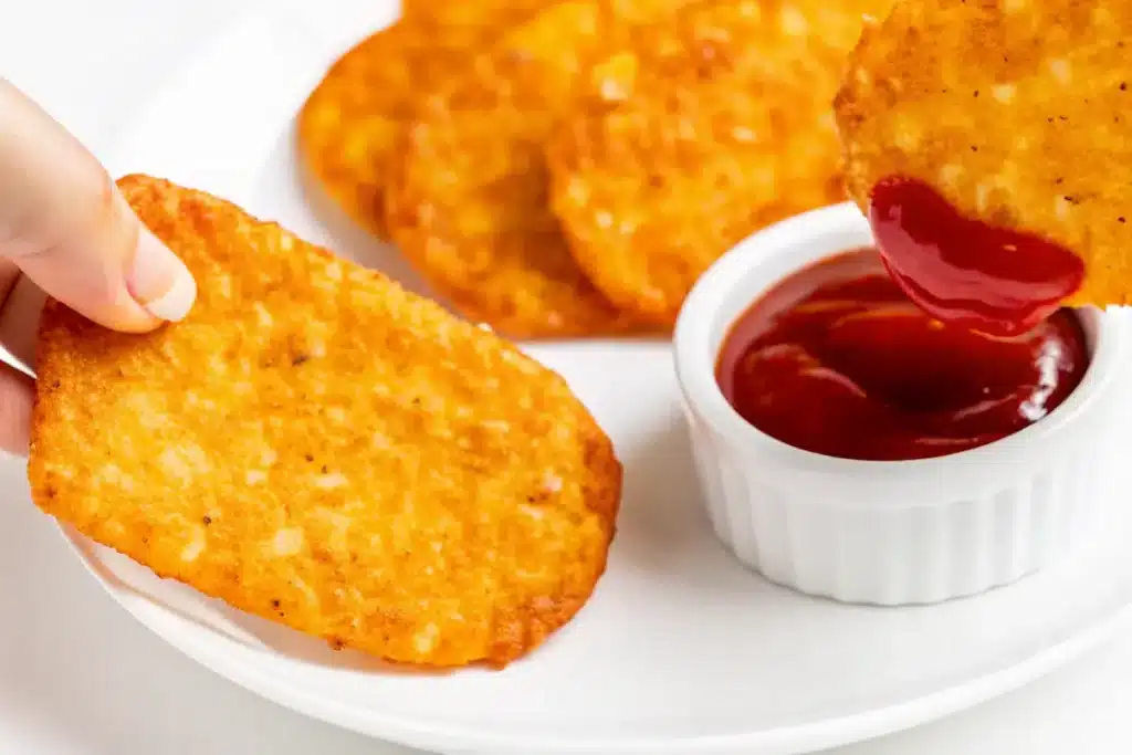 crispy hash brown patty dipped in ketchup