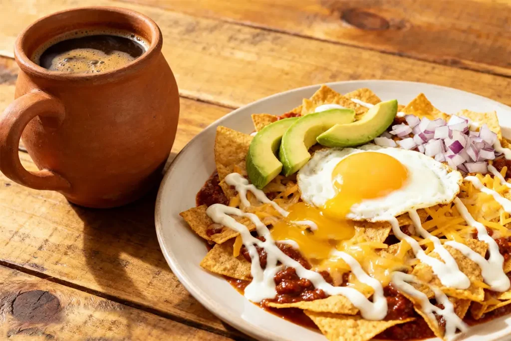 Receta de Chilaquiles de Guajillo Auténticos 11 Receta de chilaquiles de guajillo servidos con huevo, aguacate y café de olla.